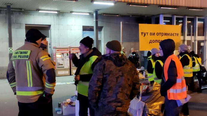 wolontariusze i strażacy czekający na uchodźców na peronie fot. K. Adamska